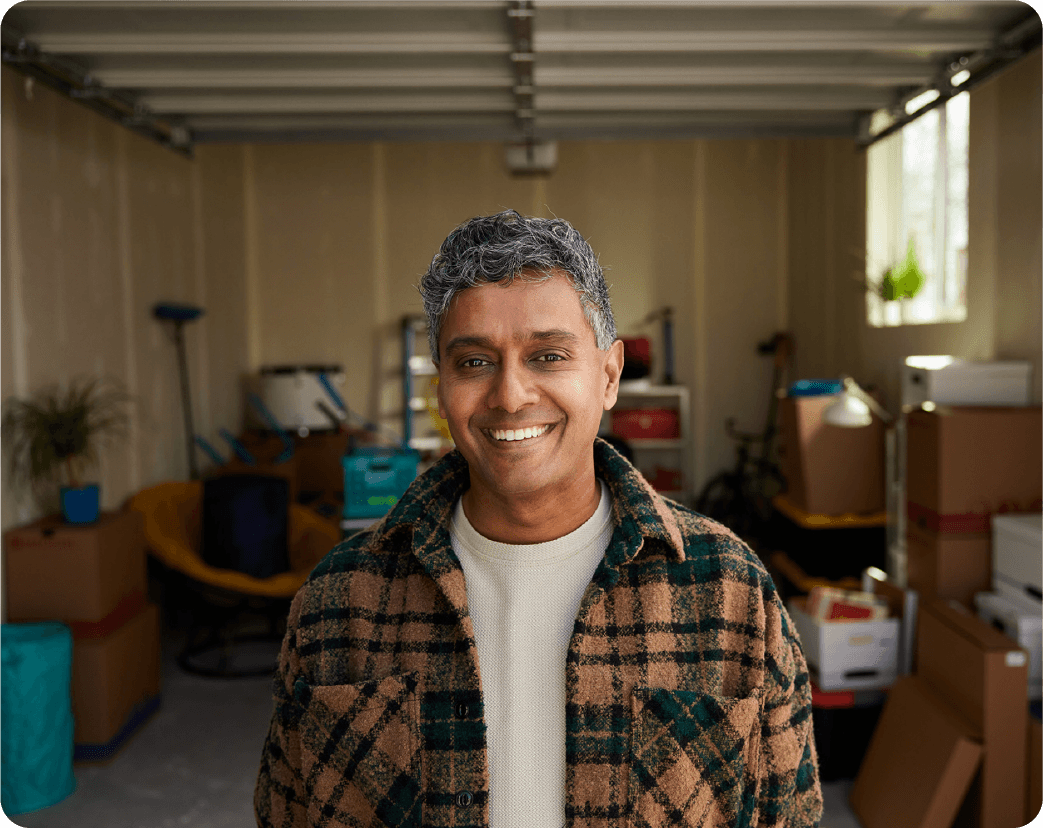 A man stands in front of an empty garage ready to be rented out on Neighbor.com for passive income as a storage unit.