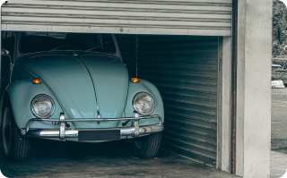 view of a half-closed garage with a car inside